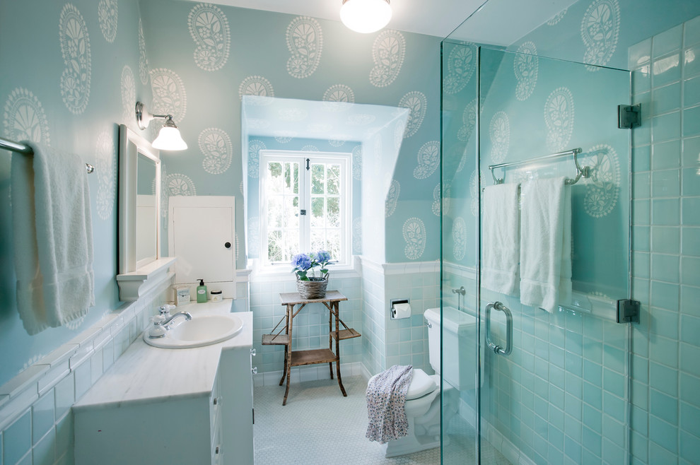 Photo of a traditional bathroom in Santa Barbara with a drop-in sink, white cabinets, a corner shower, a two-piece toilet and blue tile.