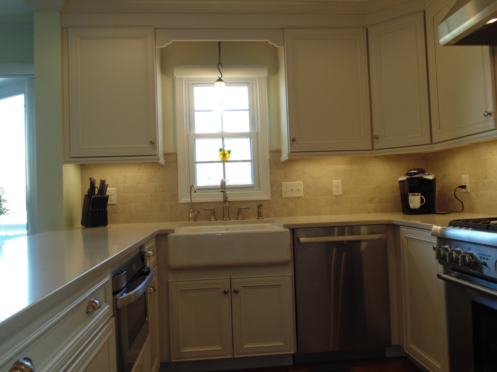 Eat-in kitchen - large transitional u-shaped medium tone wood floor and brown floor eat-in kitchen idea with a farmhouse sink, flat-panel cabinets, white cabinets, quartz countertops, beige backsplash, travertine backsplash, stainless steel appliances and beige countertops
