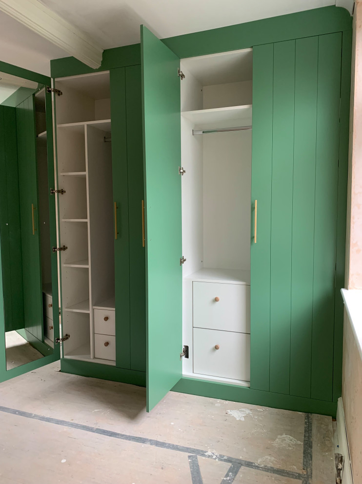 Cette photo montre une armoire encastrée tendance de taille moyenne avec un placard à porte plane, des portes de placards vertess et un sol en bois brun.