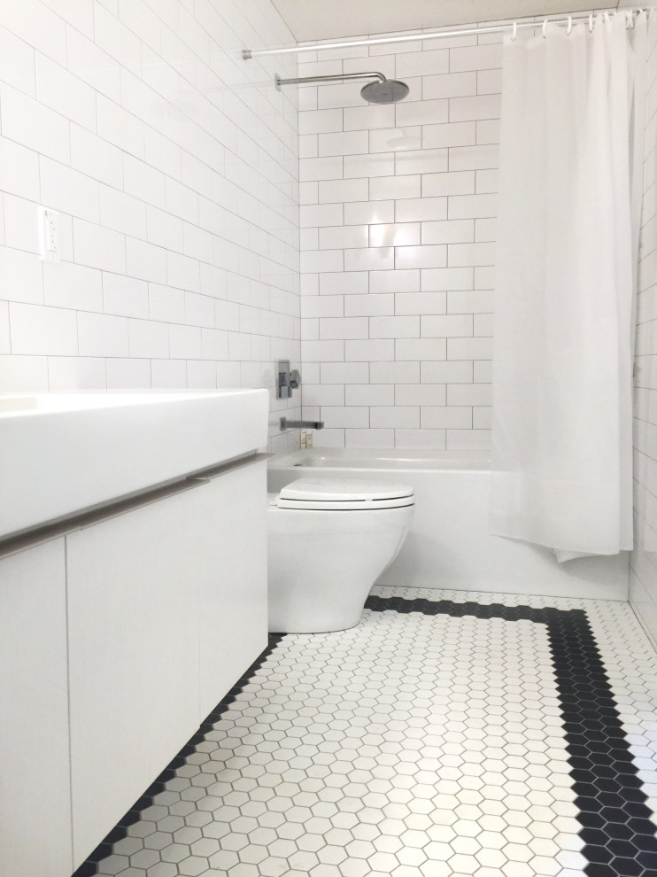 На фото: ванная комната среднего размера в стиле модернизм с плоскими фасадами, белыми фасадами, унитазом-моноблоком, белой плиткой, керамогранитной плиткой, белыми стенами, полом из керамогранита, раковиной с несколькими смесителями, белым полом, шторкой для ванной, тумбой под одну раковину и подвесной тумбой