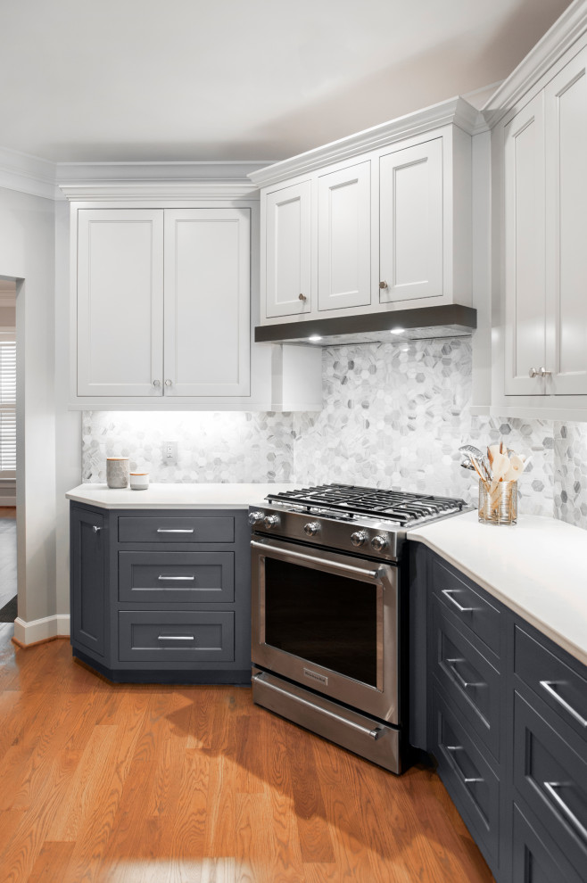 Inredning av ett klassiskt mellanstort grå grått kök, med en undermonterad diskho, luckor med profilerade fronter, grå skåp, bänkskiva i kvarts, grått stänkskydd, stänkskydd i marmor, rostfria vitvaror, mellanmörkt trägolv, en halv köksö och orange golv