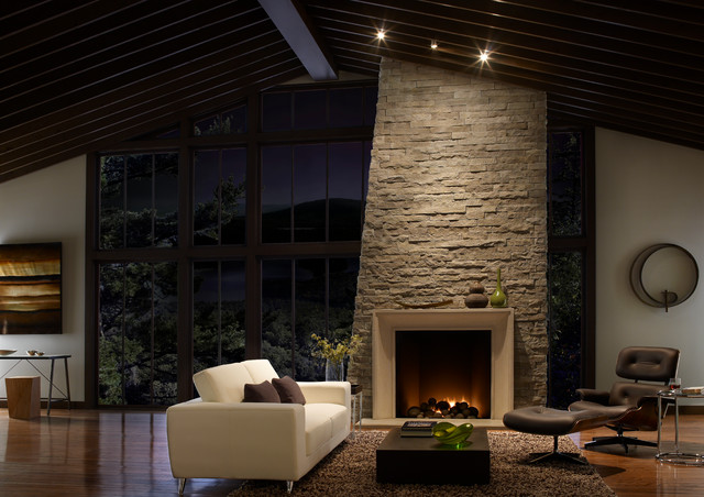 Warm Open Living Room With High Ceilings And Stone Fireplace
