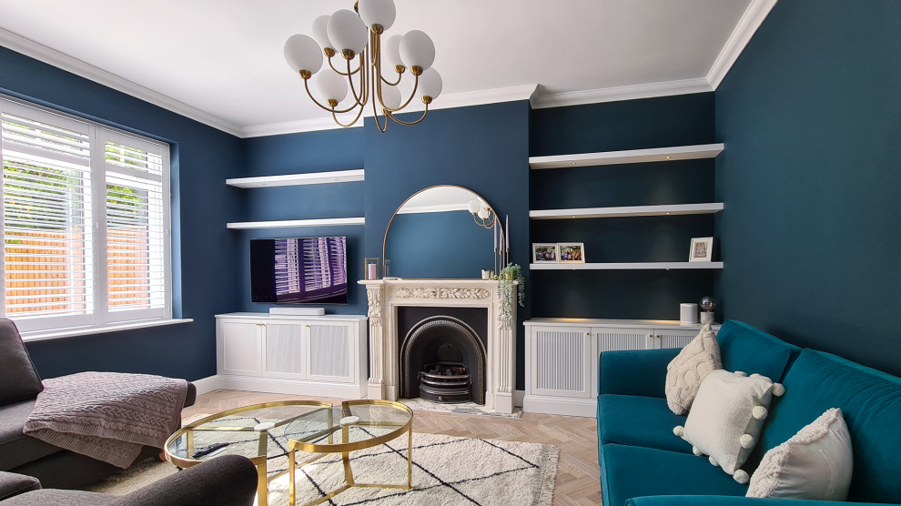 На фото: гостиная комната среднего размера в стиле модернизм с синими стенами, полом из ламината, стандартным камином, фасадом камина из камня, мультимедийным центром и коричневым полом с