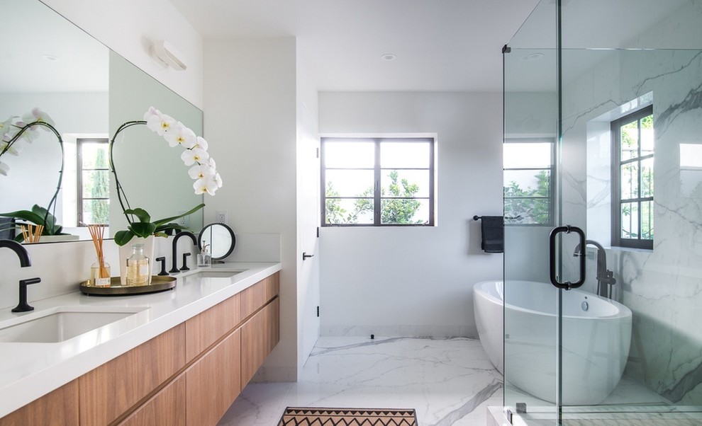 Inspiration for a mid-sized modern bathroom in Los Angeles with flat-panel cabinets, medium wood cabinets, a freestanding tub, an open shower, black and white tile, marble, white walls, marble floors, an undermount sink, soapstone benchtops, white floor, a hinged shower door and white benchtops.
