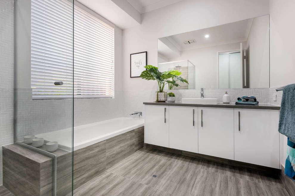 Design ideas for a mid-sized contemporary 3/4 bathroom in Perth with flat-panel cabinets, white cabinets, a drop-in tub, a corner shower, a one-piece toilet, white tile, porcelain tile, white walls, porcelain floors, a drop-in sink, engineered quartz benchtops, brown floor and a hinged shower door.