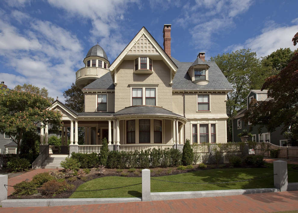 This is an example of a large traditional three-storey exterior in Boston with wood siding and a gable roof.