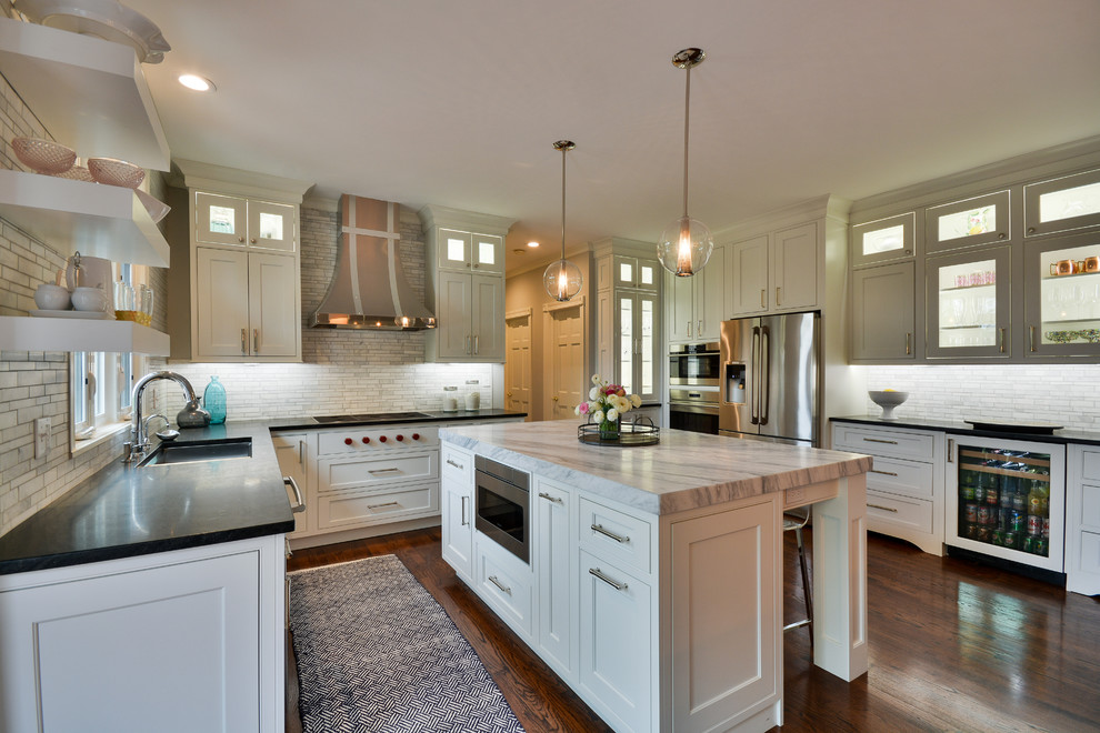 Inspiration for a large transitional u-shaped dark wood floor and brown floor eat-in kitchen remodel in Chicago with an undermount sink, recessed-panel cabinets, white cabinets, soapstone countertops, gray backsplash, marble backsplash, stainless steel appliances and an island