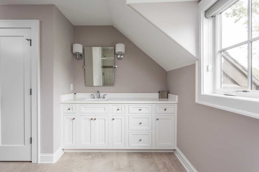 Photo of a mid-sized traditional bathroom in Indianapolis with shaker cabinets, white cabinets, beige walls, medium hardwood floors, an undermount sink, quartzite benchtops, brown floor and white benchtops.