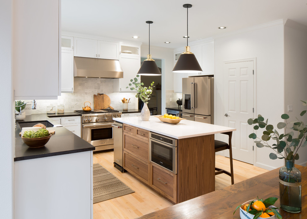 Eat-in kitchen - mid-sized transitional l-shaped light wood floor and brown floor eat-in kitchen idea in Seattle with an undermount sink, shaker cabinets, white cabinets, quartz countertops, multicolored backsplash, marble backsplash, stainless steel appliances and an island
