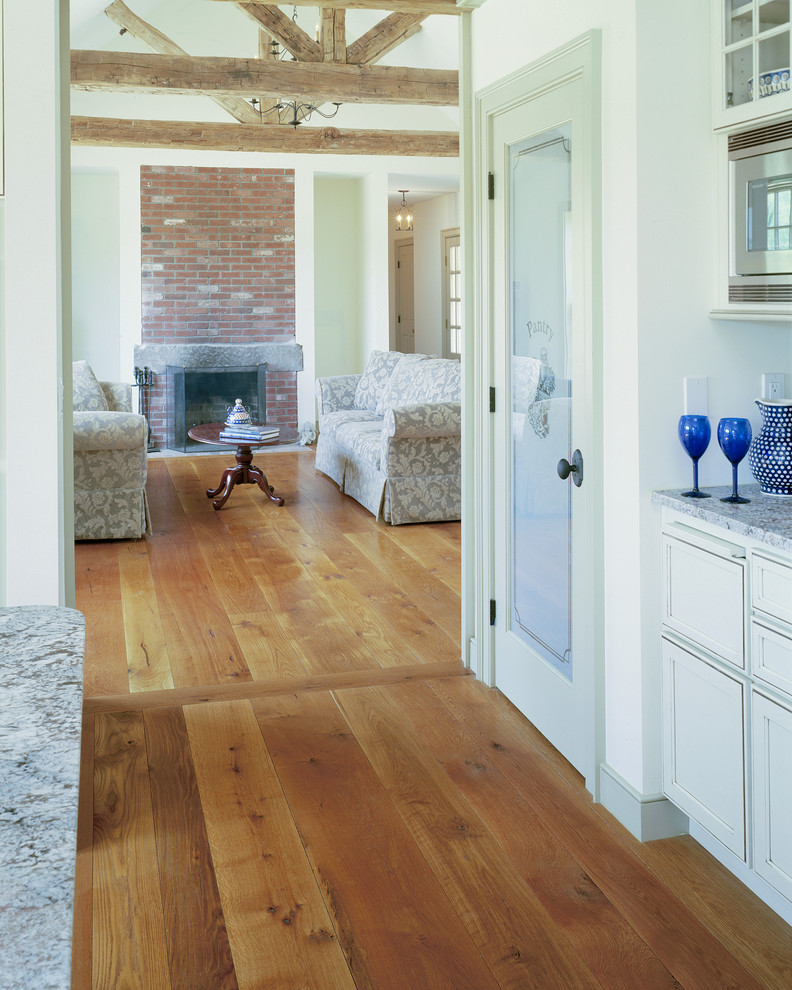Photo of a mid-sized arts and crafts hallway in Bridgeport with white walls and medium hardwood floors.