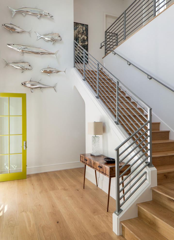 This is an example of a beach style wood l-shaped staircase in Miami with wood risers and metal railing.