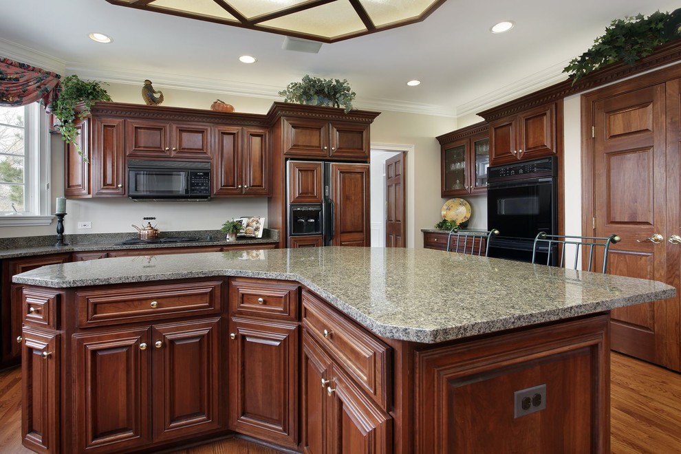 Design ideas for a large traditional u-shaped separate kitchen in Denver with an undermount sink, raised-panel cabinets, brown cabinets, granite benchtops, grey splashback, stone slab splashback, stainless steel appliances, medium hardwood floors, with island and brown floor.