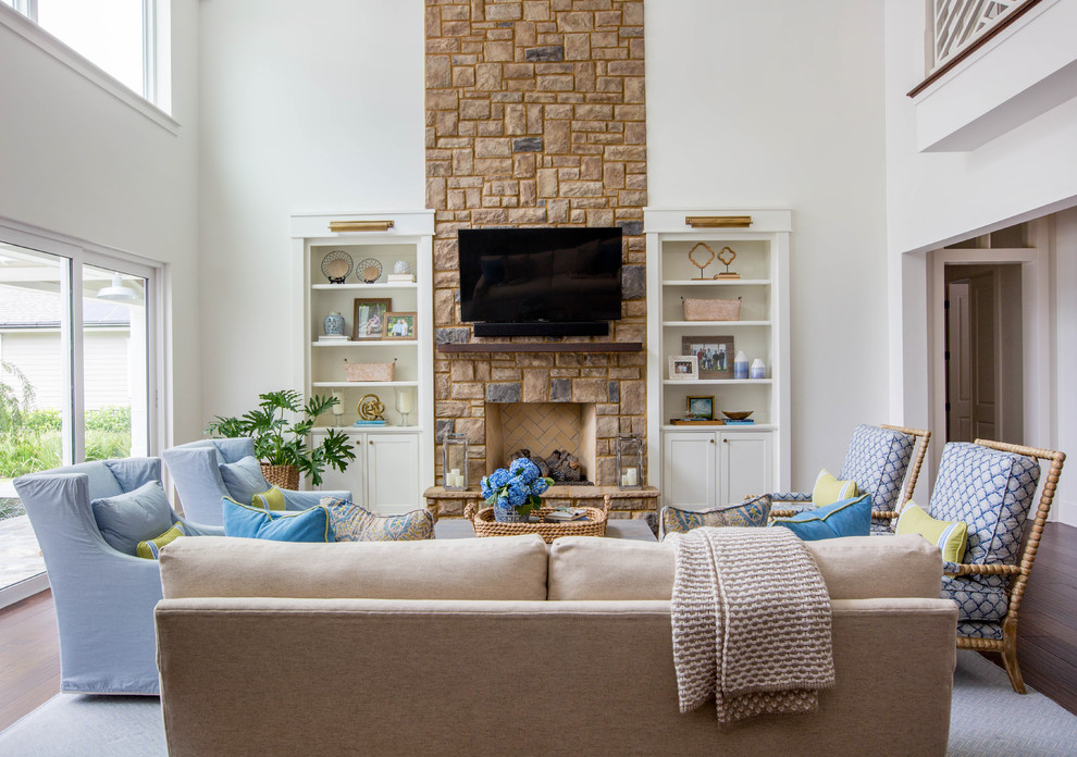 Design ideas for a transitional living room in Jacksonville with white walls, medium hardwood floors, a standard fireplace, a stone fireplace surround, a wall-mounted tv and brown floor.
