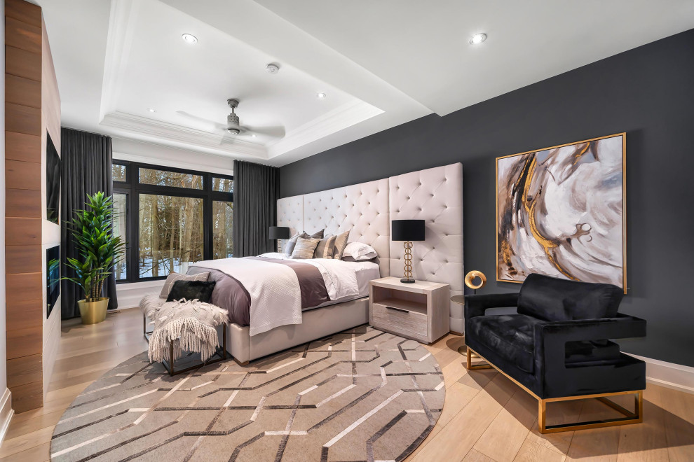 Ejemplo de dormitorio principal minimalista grande con paredes grises, suelo de madera clara, chimeneas suspendidas y suelo beige