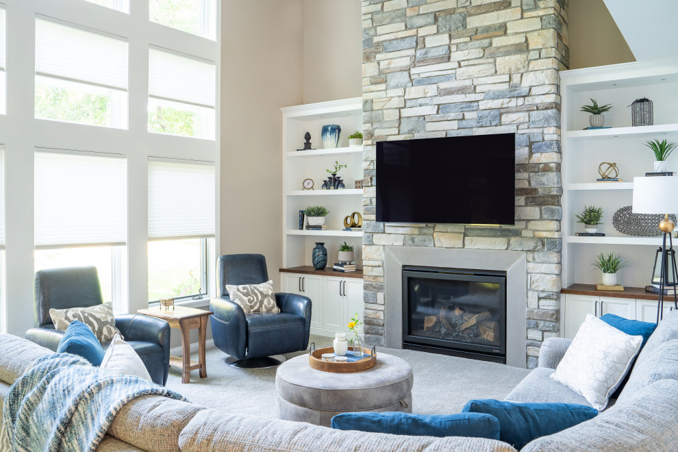 Стильный дизайн: большая двухуровневая гостиная комната в стиле неоклассика (современная классика) с серыми стенами, фасадом камина из камня, телевизором на стене, коричневым полом и ковровым покрытием - последний тренд