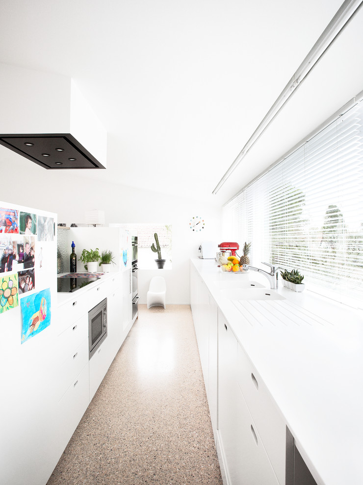 Inspiration for a modern galley separate kitchen in Other with an integrated sink, flat-panel cabinets and white cabinets.