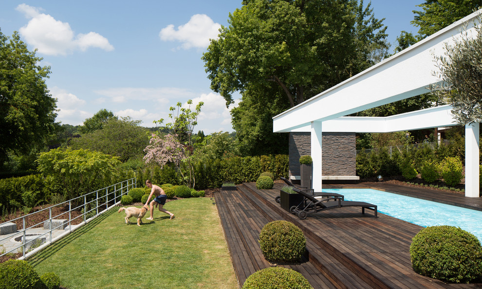 Modern backyard rectangular lap pool in Stuttgart with decking.