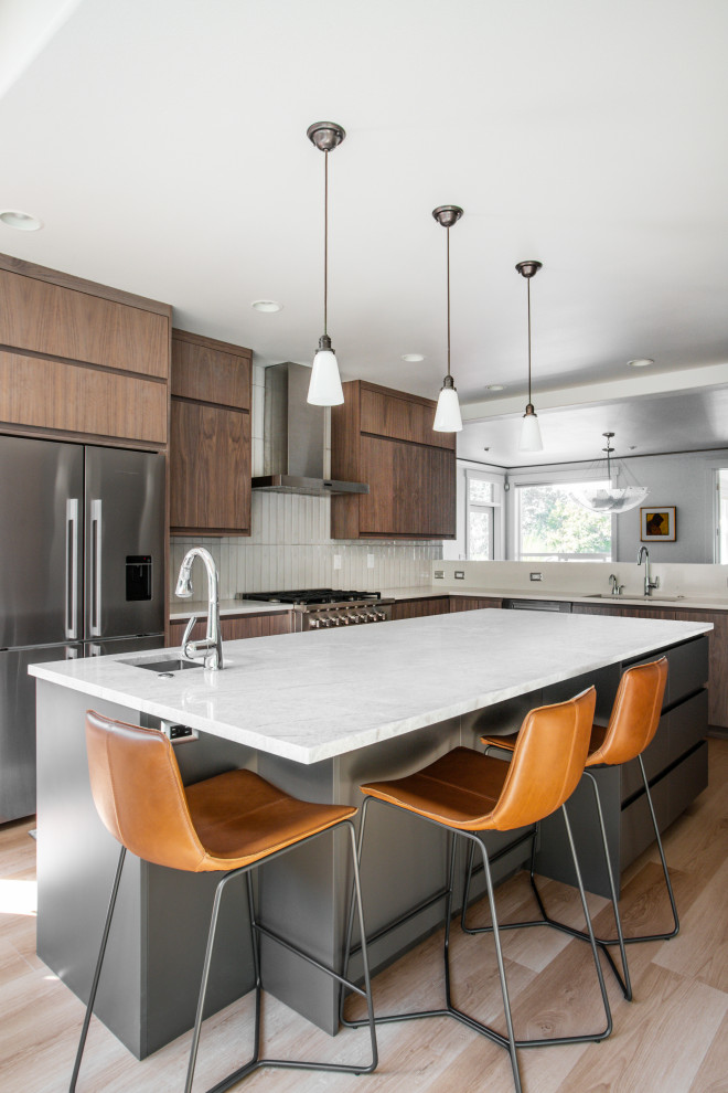 Inspiration for a large modern u-shaped laminate floor, brown floor and vaulted ceiling eat-in kitchen remodel in Seattle with a single-bowl sink, flat-panel cabinets, medium tone wood cabinets, quartzite countertops, white backsplash, porcelain backsplash, stainless steel appliances, an island and white countertops