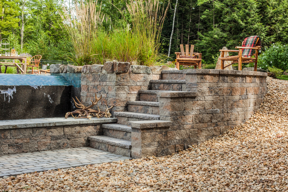 Inspiration for a mid-sized rustic backyard retaining wall landscape.