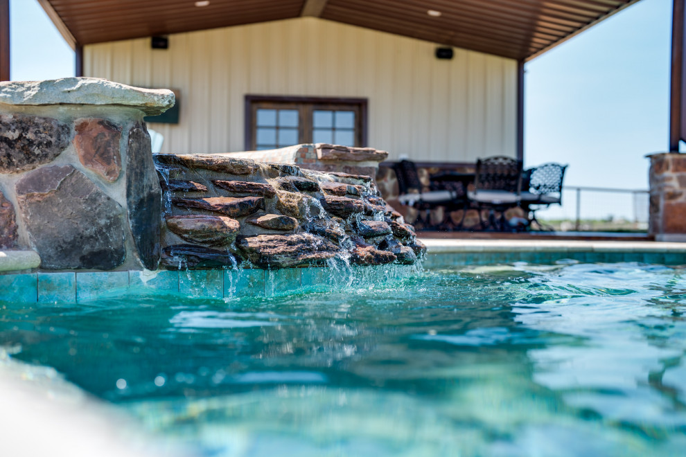 Example of a mid-sized mountain style backyard stone and custom-shaped hot tub design in Austin