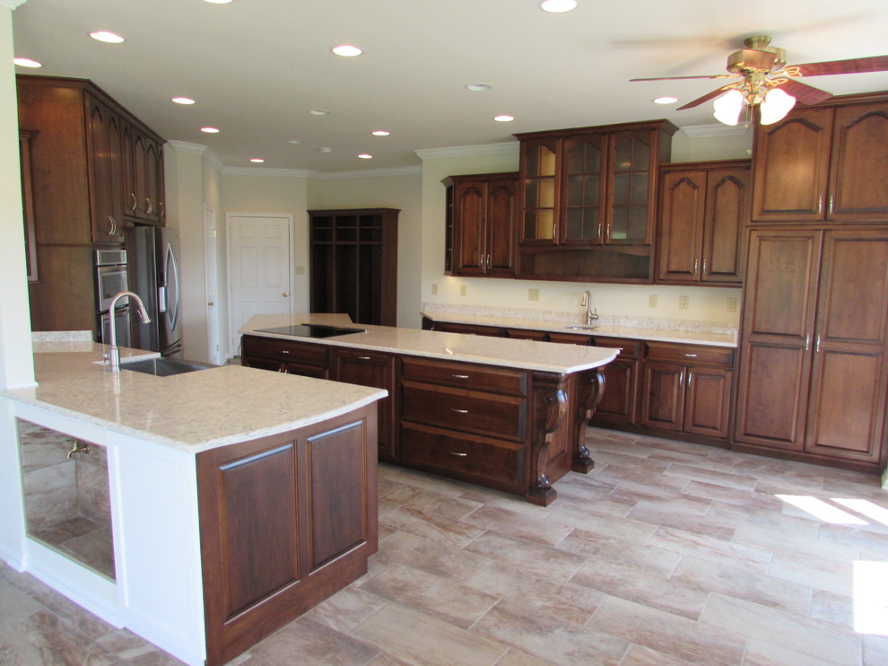 Eat-in kitchen - large transitional galley ceramic tile eat-in kitchen idea in DC Metro with a farmhouse sink, raised-panel cabinets, dark wood cabinets, granite countertops, stainless steel appliances and an island