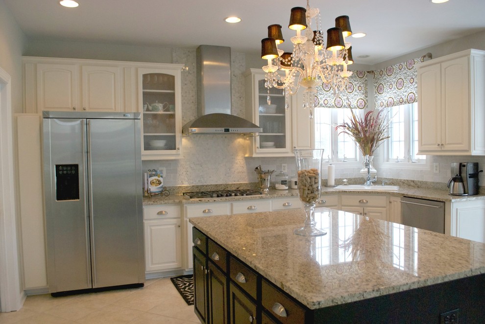 This is an example of a large traditional l-shaped eat-in kitchen in DC Metro with raised-panel cabinets, granite benchtops, stainless steel appliances, ceramic floors, a drop-in sink, white cabinets, white splashback, mosaic tile splashback, with island, beige floor and multi-coloured benchtop.