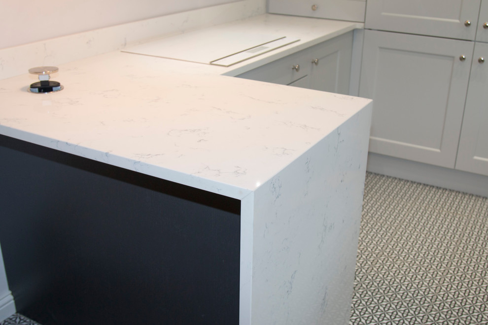 Photo of a small traditional u-shaped enclosed kitchen in Belfast with a submerged sink, recessed-panel cabinets, grey cabinets, quartz worktops, white splashback, stone slab splashback, stainless steel appliances, ceramic flooring and a breakfast bar.