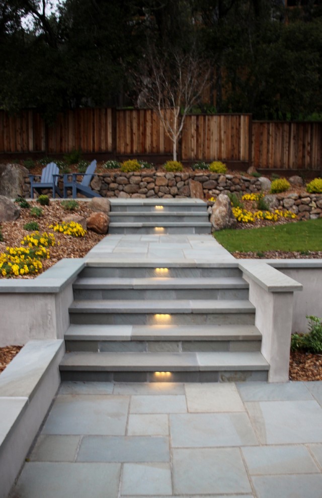 Inspiration for a large contemporary backyard partial sun garden for winter in San Francisco with natural stone pavers and a retaining wall.