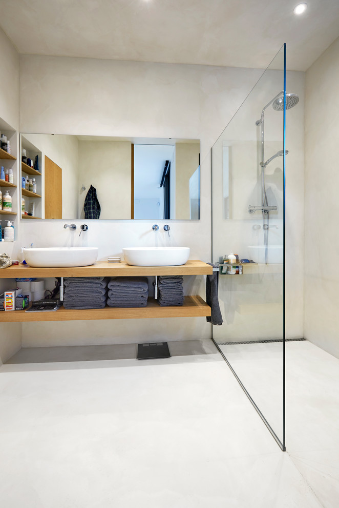 Photo of a contemporary 3/4 bathroom in Other with open cabinets, medium wood cabinets, a curbless shower, a vessel sink, wood benchtops, beige walls, concrete floors, beige floor, an open shower and brown benchtops.