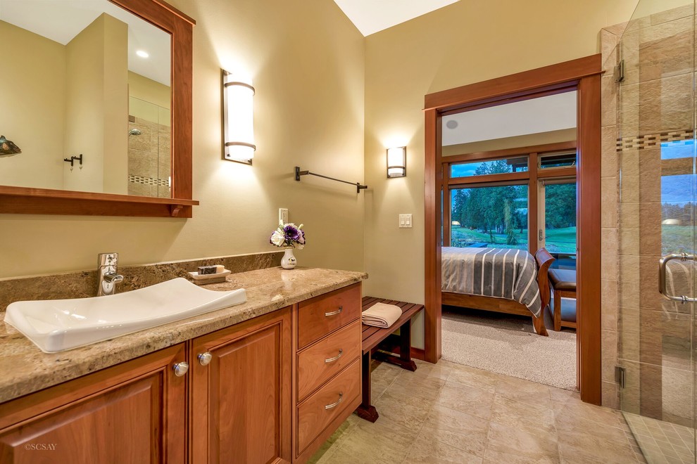 Photo of a large master bathroom in Seattle with raised-panel cabinets, medium wood cabinets, a curbless shower, beige walls, slate floors, a vessel sink, granite benchtops, multi-coloured floor, a hinged shower door and beige benchtops.