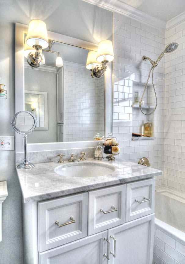 Small arts and crafts master bathroom in Denver with recessed-panel cabinets, a drop-in tub, a shower/bathtub combo, a two-piece toilet, white tile, ceramic tile, white walls, marble floors, marble benchtops and an undermount sink.