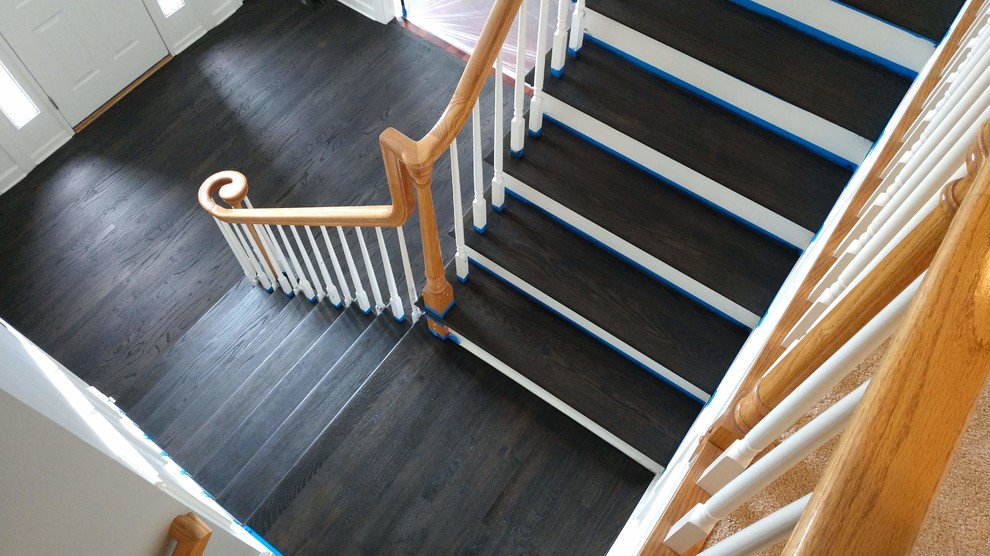 Modelo de escalera en L moderna con escalones de madera, contrahuellas de madera y barandilla de madera