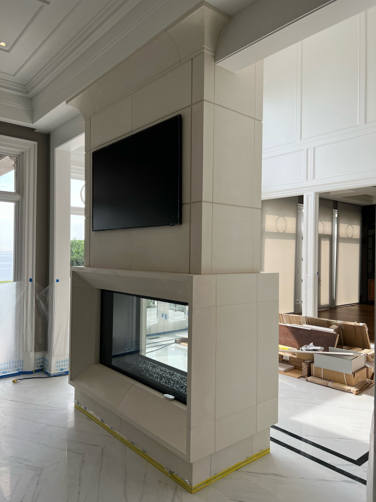 Idéer för att renovera ett mycket stort funkis allrum med öppen planlösning, med ett finrum, beige väggar, marmorgolv, en dubbelsidig öppen spis, en spiselkrans i sten, en väggmonterad TV och vitt golv