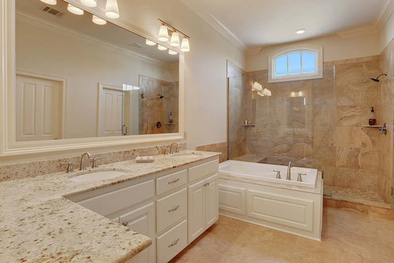 Inspiration for a large transitional master bathroom in New Orleans with raised-panel cabinets, white cabinets, a drop-in tub, an alcove shower, beige tile, white walls, ceramic floors and granite benchtops.