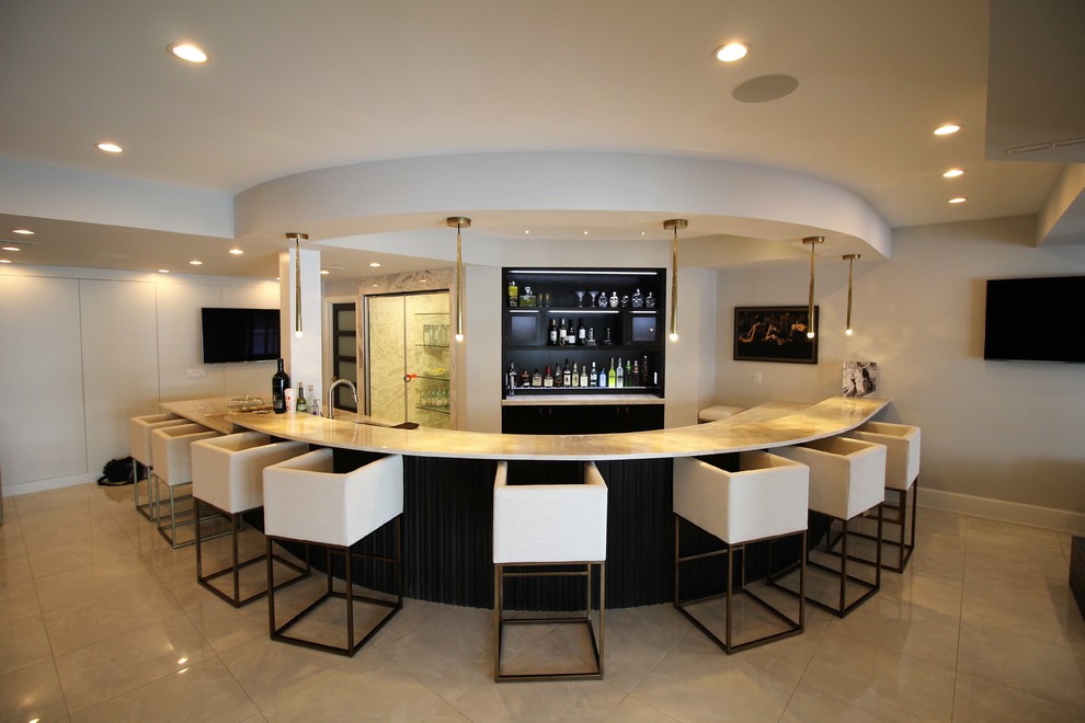 This is an example of a large contemporary u-shaped seated home bar in Detroit with an undermount sink, open cabinets, black cabinets, limestone benchtops, limestone floors and beige floor.