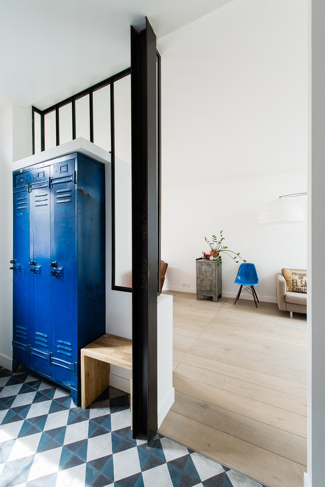 This is an example of a mid-sized scandinavian mudroom in Paris with white walls.