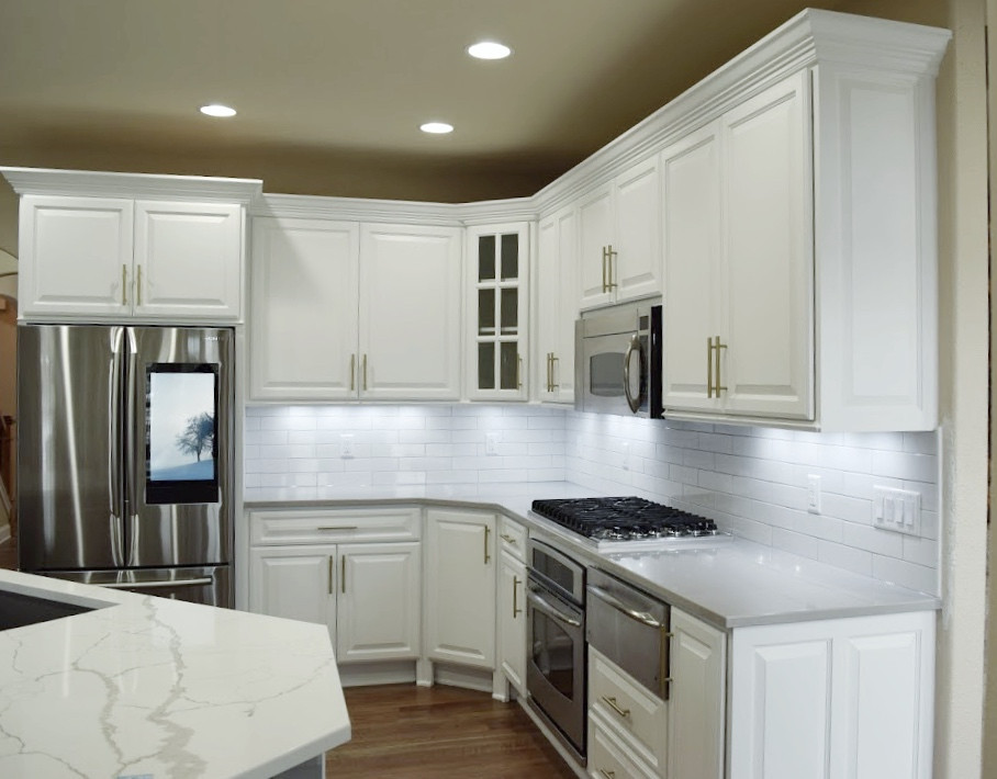 Inspiration for a large transitional l-shaped dark wood floor eat-in kitchen remodel in Milwaukee with an undermount sink, raised-panel cabinets, white cabinets, white backsplash, stainless steel appliances, an island and multicolored countertops