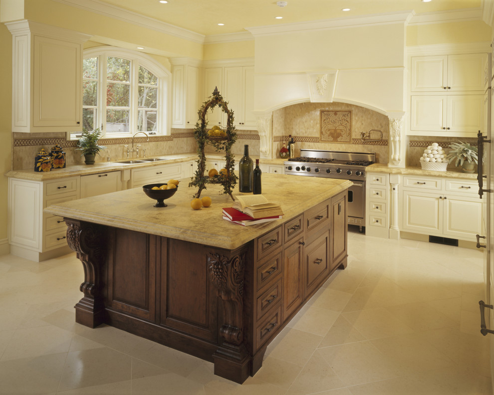 Large traditional u-shaped kitchen in Los Angeles with stainless steel appliances, an undermount sink, raised-panel cabinets, white cabinets, beige splashback, marble benchtops, porcelain splashback, porcelain floors and with island.