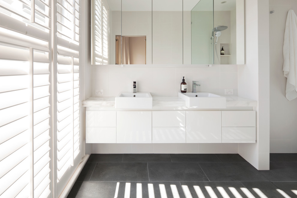 Design ideas for a small modern 3/4 bathroom in Melbourne with a vessel sink, flat-panel cabinets, white cabinets, marble benchtops, an open shower, white tile, porcelain tile, white walls and limestone floors.