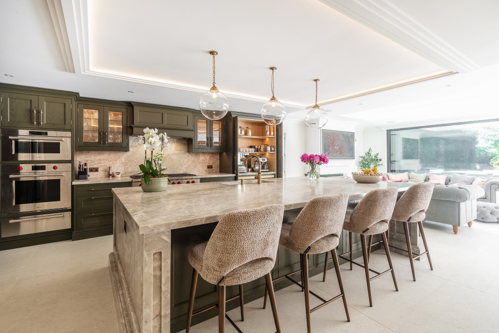 Inspiration for a classic galley kitchen in Surrey with a submerged sink, recessed-panel cabinets, green cabinets, beige splashback, stone slab splashback, stainless steel appliances, an island, beige floors, beige worktops and a drop ceiling.