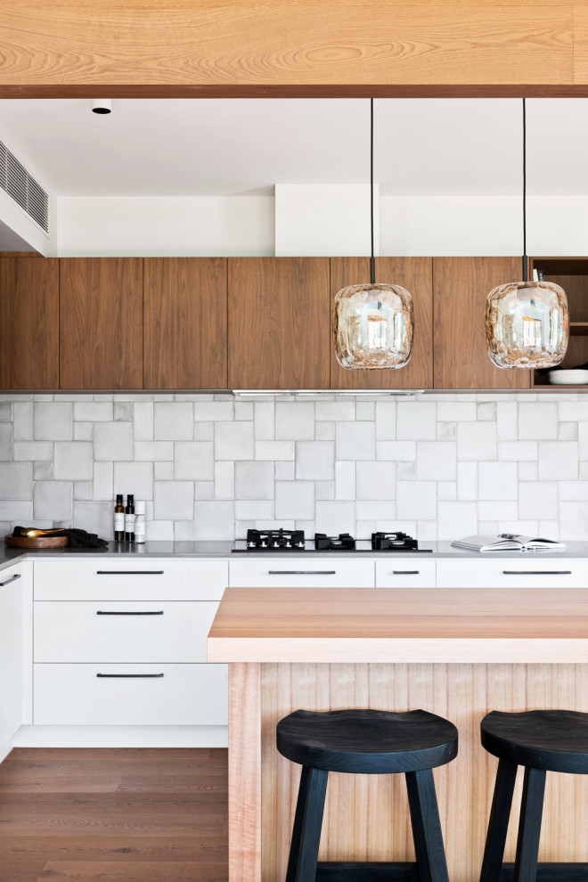 Idéer för ett minimalistiskt kök, med mellanmörkt trägolv och en köksö