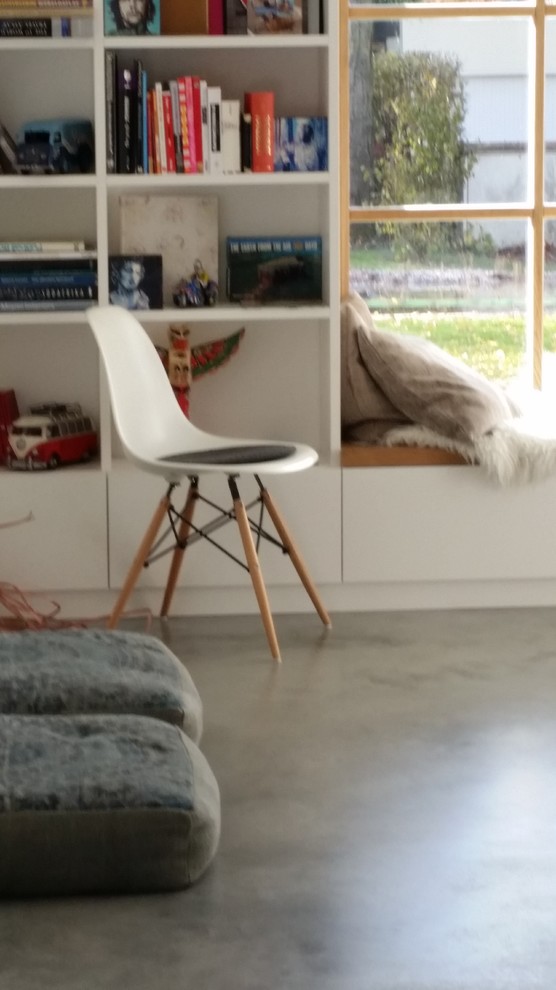 Modernes Wohnzimmer mit weißer Wandfarbe und Betonboden in München