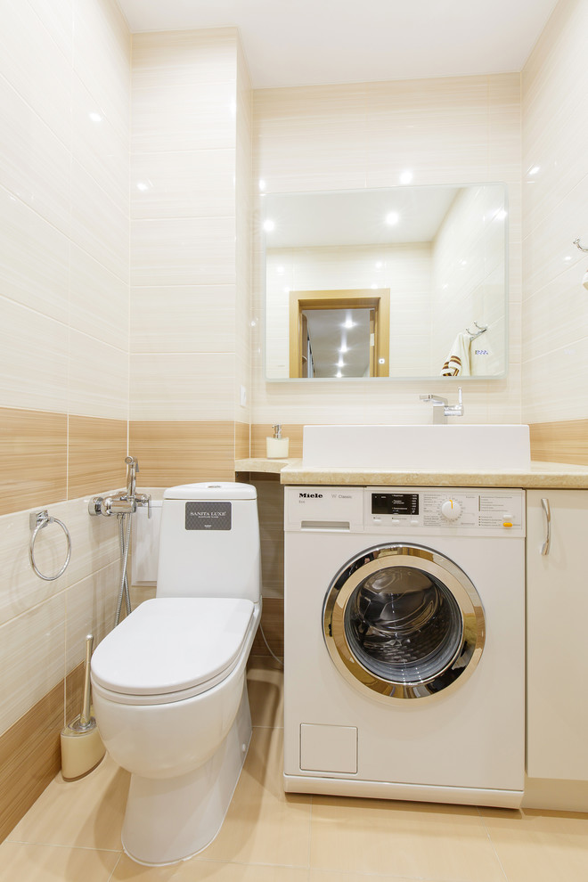 Small contemporary powder room in Other with a two-piece toilet, beige tile, ceramic tile, beige walls, ceramic floors, a drop-in sink, solid surface benchtops and beige floor.