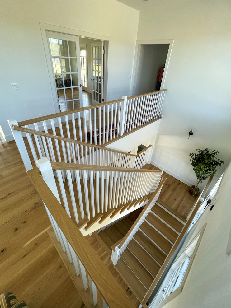Medium sized rural wood u-shaped wood railing staircase in DC Metro with wood risers and tongue and groove walls.