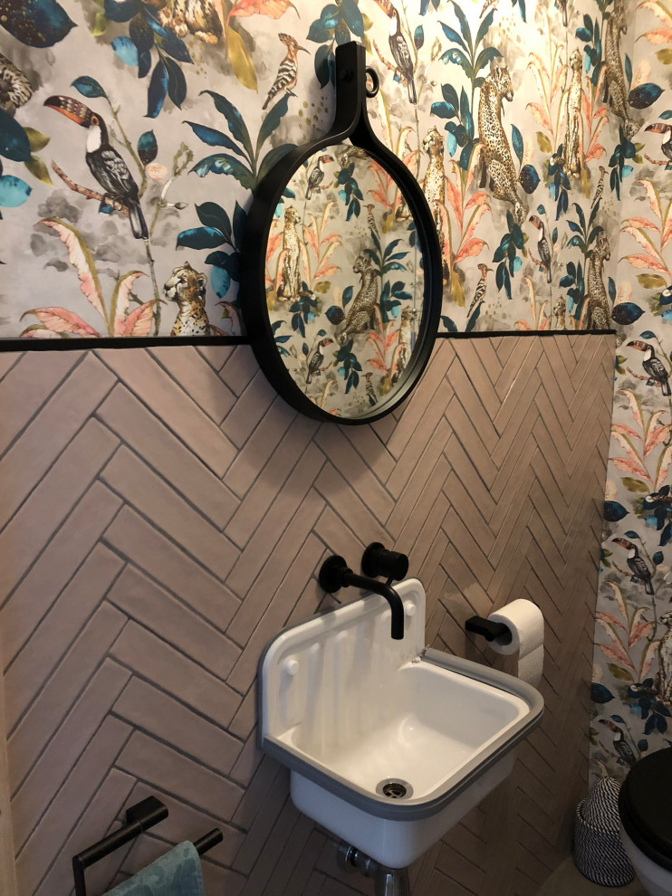 Kleine Eklektische Gästetoilette mit rosa Fliesen, Porzellanfliesen, Wandwaschbecken, schwebendem Waschtisch, Tapetenwänden und Toilette mit Aufsatzspülkasten in London