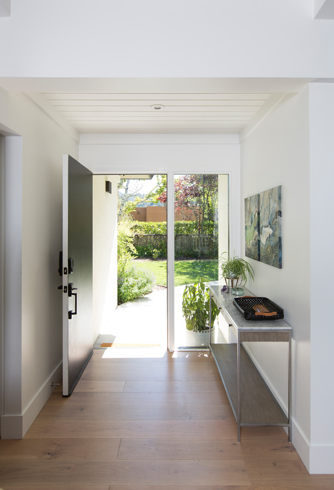 Esempio di un grande ingresso moderno con pareti bianche, parquet chiaro, una porta singola, pavimento beige e travi a vista