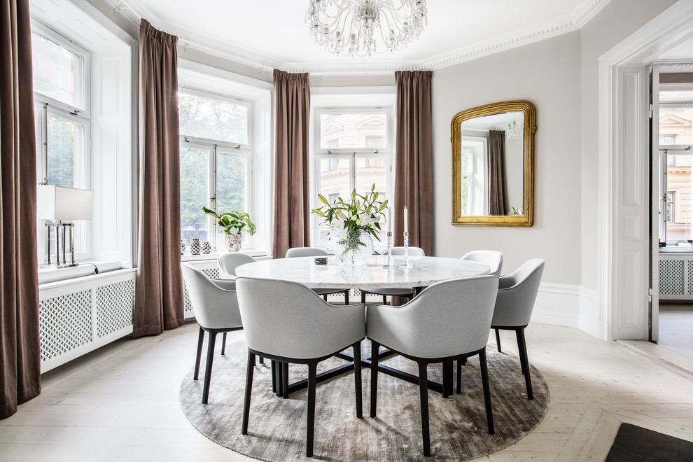 Design ideas for a large traditional separate dining room in Stockholm with beige walls, light hardwood floors and no fireplace.