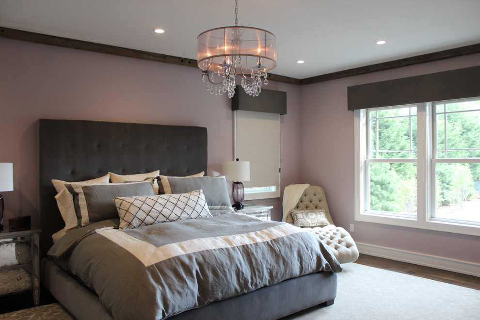 Inspiration for a large traditional master bedroom in New York with pink walls, medium hardwood floors, no fireplace and brown floor.