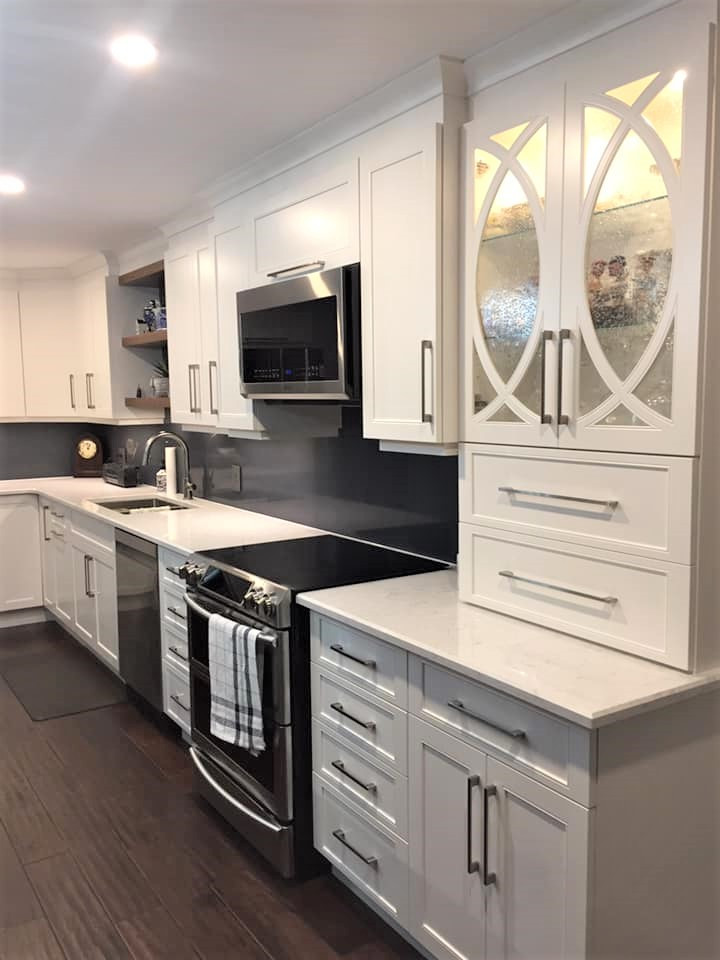 Inspiration for a mid-sized transitional l-shaped dark wood floor and brown floor eat-in kitchen remodel in Ottawa with an undermount sink, recessed-panel cabinets, white cabinets, quartz countertops, blue backsplash, quartz backsplash, stainless steel appliances, an island and white countertops