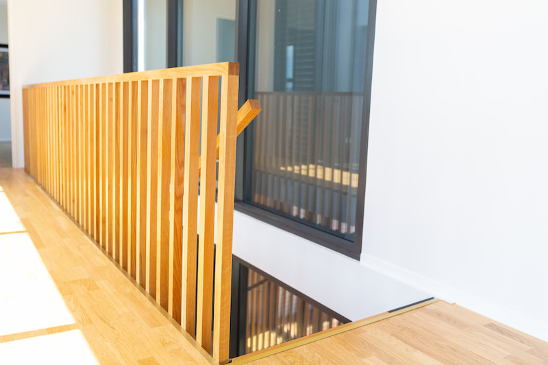 Идея дизайна: лестница на больцах, среднего размера в современном стиле с деревянными ступенями и деревянными перилами без подступенок